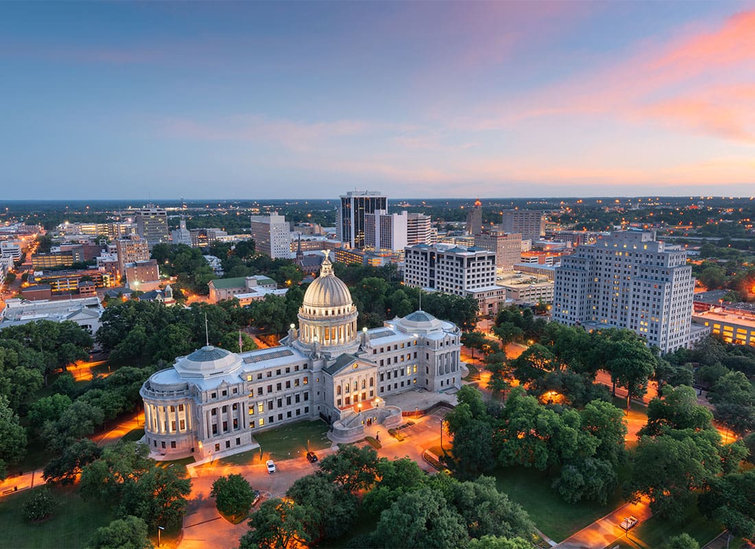 Jackson, MS - Aerial View of Capitol Buildings Surrounded by Trees in Downtown Jackson Mississippi at Sunset